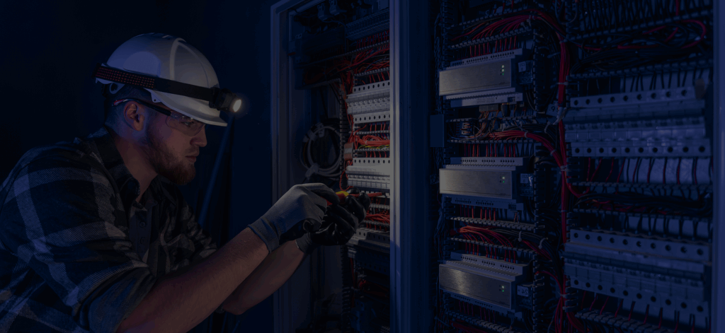 Electrician servicing switchboard equipment