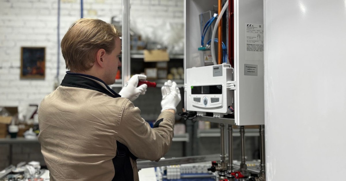 Technician servicing the internal components of a wall-mounted tankless water heater during installation